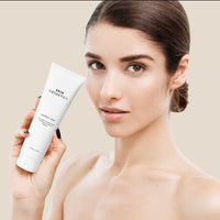 Close-up of Nourish Clean Cleansing Cream to damp skin, illustrating its creamy consistency.