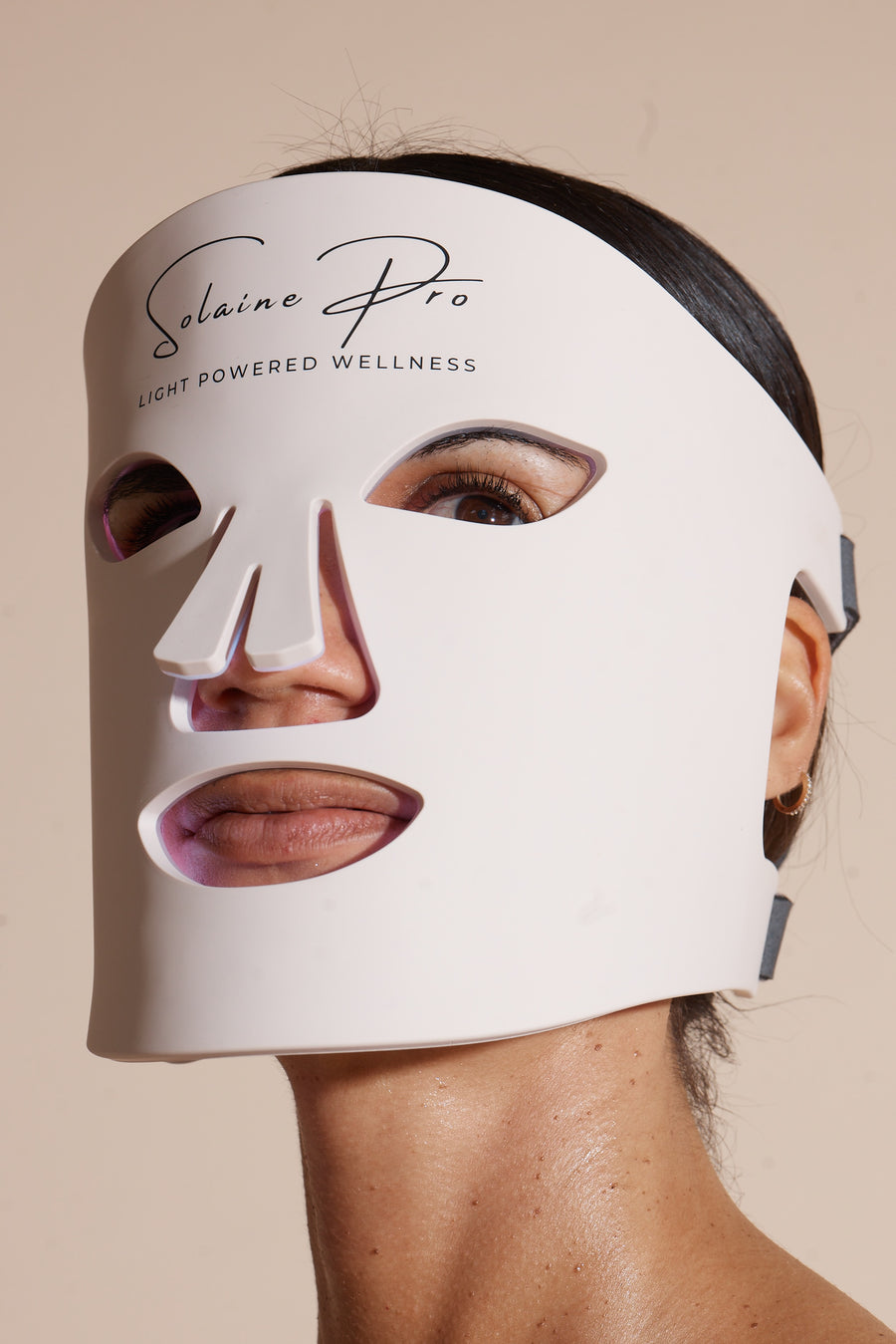 Model relaxing while using the Solaine Pro LED face mask, demonstrating its soothing and therapeutic benefits for skincare